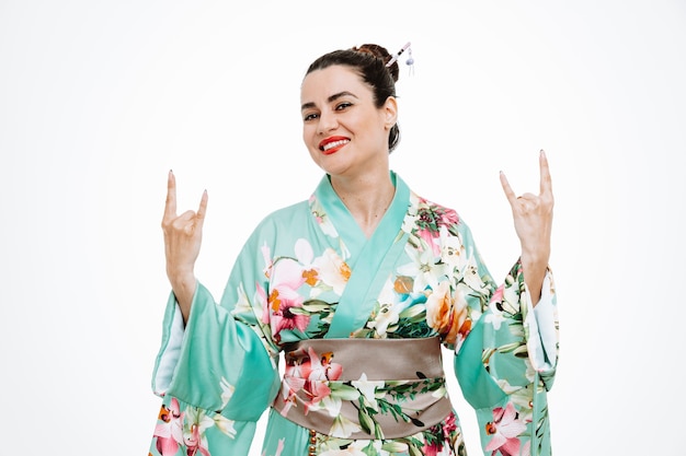 Vrouw in traditionele Japanse kimono die rotsteken op wit toont