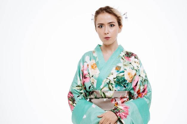 Vrouw in traditionele japanse kimono verrast en bezorgd op wit