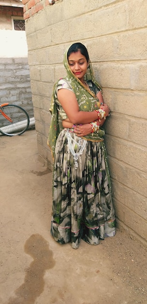 Foto vrouw in traditionele kleding die bij de muur staat