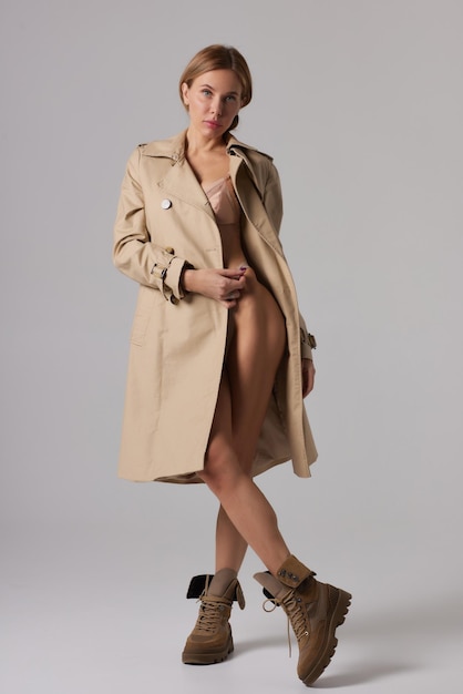 Vrouw in trenchcoat en ondergoed in studio