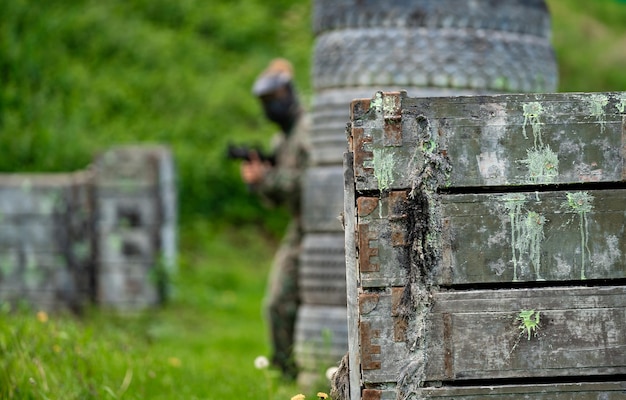 Vrouw in uniform met een pistool in militaire paintballtraining