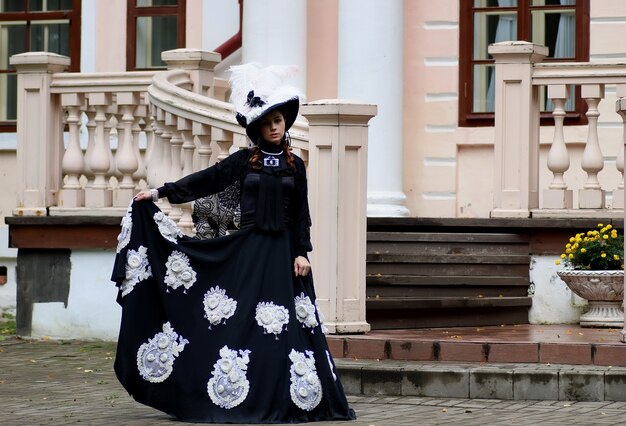 Vrouw in vintage jurk op veranda van kasteel