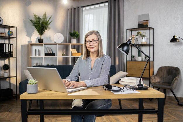 Vrouw in vrijetijdskleding met computer op verre werkplek