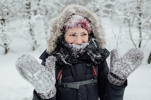 Vrouw in warme kleding die in de winter op de berg staat