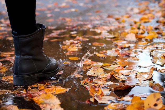 Vrouw in weer verzegelde laarzen gaan door straten in de herfst