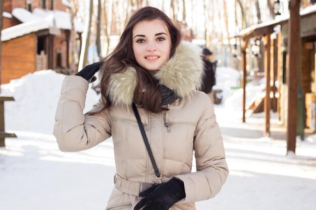 Vrouw in winterpark in de buurt van enkele gebouwen