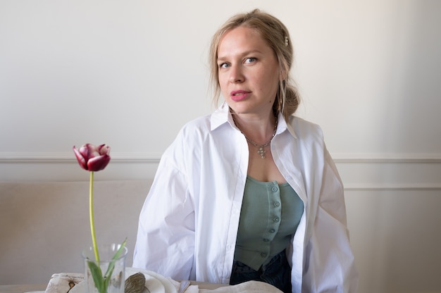 Foto vrouw in wit overhemd aan tafel.