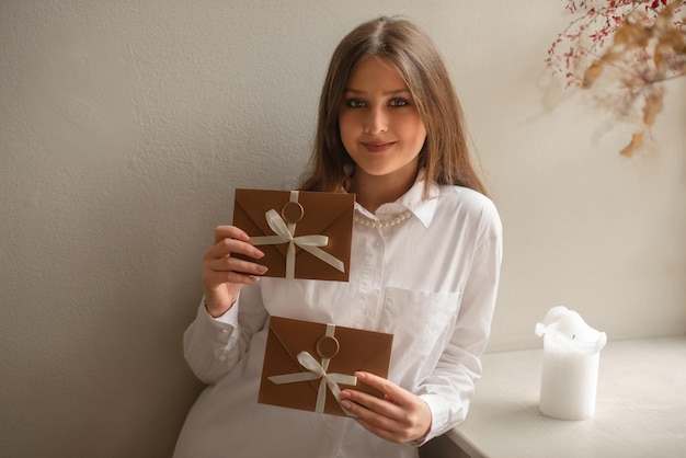 Vrouw in wit overhemd die een cadeaubon geeft in licht interieur