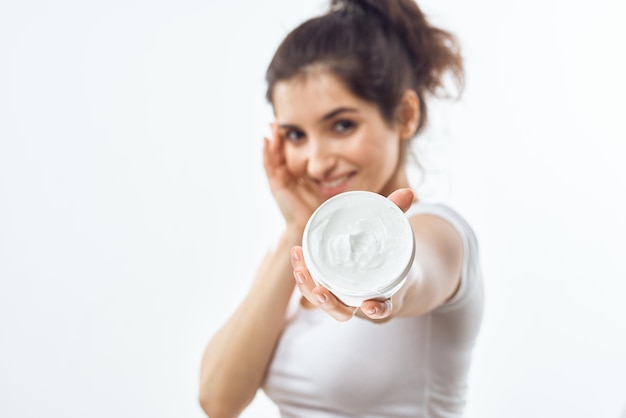 Vrouw in wit t-shirt zalfpotje huidverzorging hydraterende dermatologie Foto van hoge kwaliteit