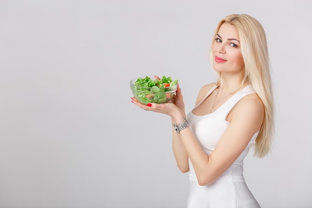 Vrouw in witte jurk met frisse salade