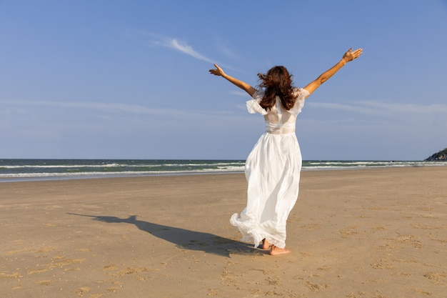 Vrouw in witte jurk op het strand