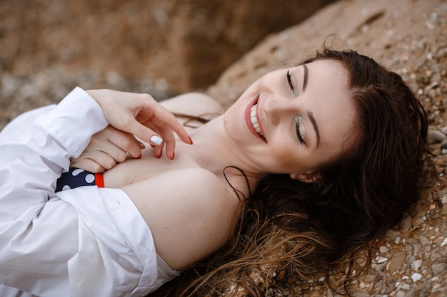 Vrouw in witte kleding verfrissend aan zee.