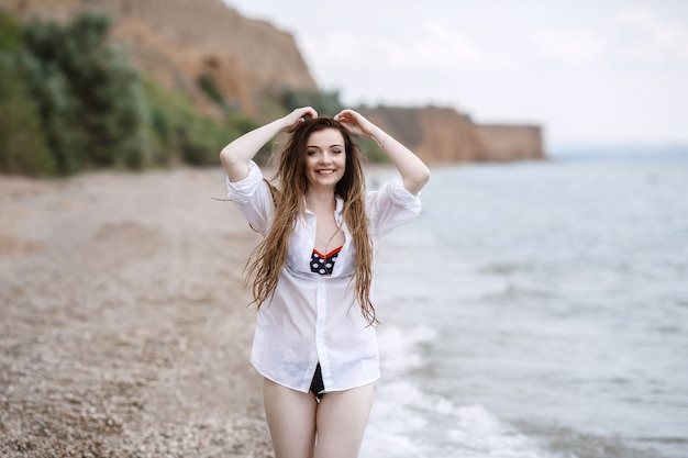 Vrouw in witte kleding verfrissend aan zee.