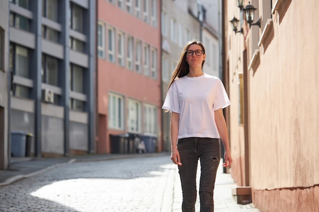 Vrouw in witte lege t-shirt met een bril in de stad