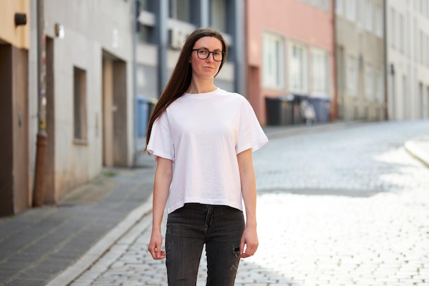 Vrouw in witte lege t-shirt met een bril in de stad