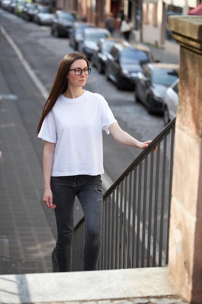 Vrouw in witte lege t-shirt met een bril in de stad