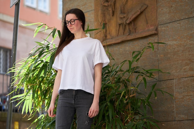 Vrouw in witte lege t-shirt met een bril in de stad