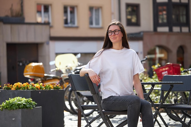 Vrouw in witte lege t-shirt met een bril in de stad