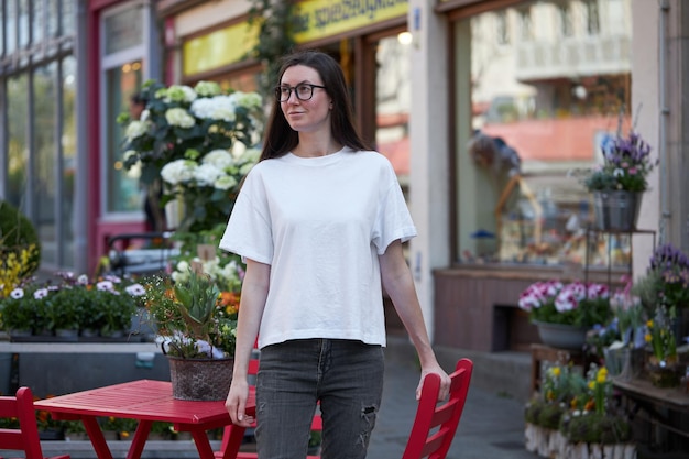 Vrouw in witte lege t-shirt met een bril in de stad