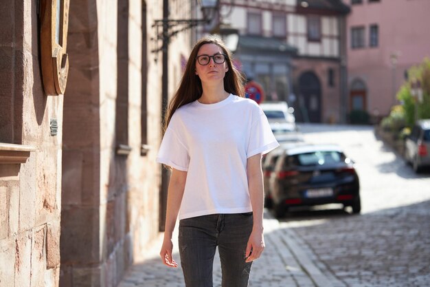 Vrouw in witte lege t-shirt met een bril in de stad