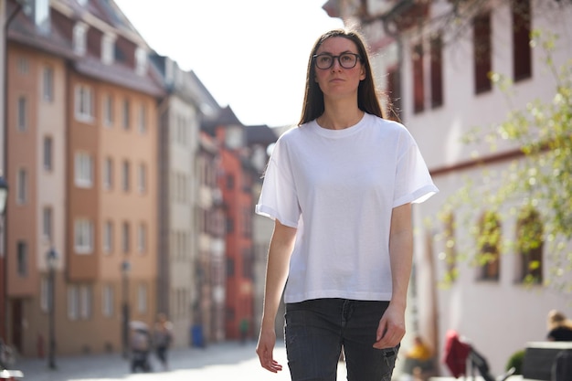 Vrouw in witte lege t-shirt met een bril in de stad