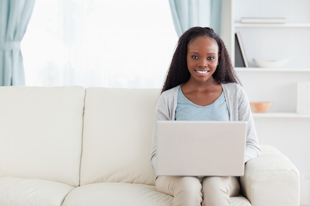 Vrouw in woonkamer met laptop