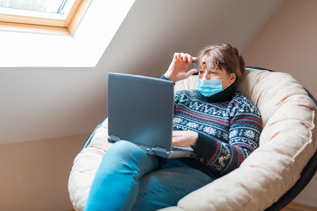 Vrouw in zelfisolatie die verre werk op laptop doet