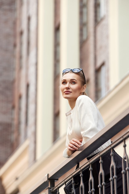 Vrouw in zonnebril in stad in zonnige dag