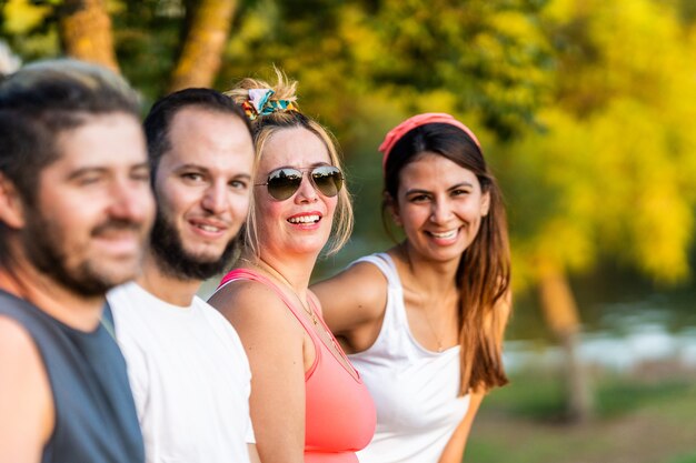 Vrouw in zonnebril staande met een groep vrienden in een park