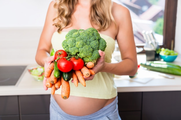 Vrouw in zwangere eten gezonde groenten