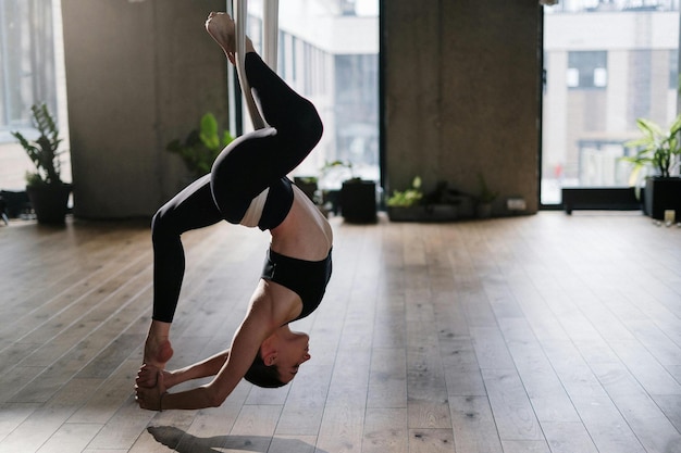 Vrouw in zwarte sportbh en zwarte leggings doet yoga
