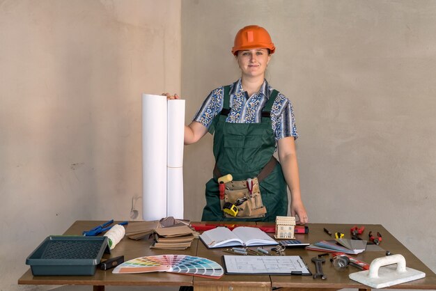 Vrouw ingenieur op werkplek met blauwdrukkenprint