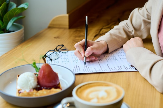 Vrouw invullen formulier aan tafel in café