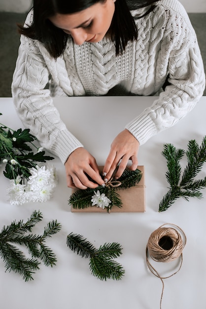 Vrouw inwikkeling presenteert. Mooie eenvoudige geschenkverpakking.