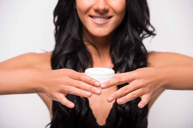 Vrouw is het aanbrengen van vochtinbrengende crème anti-rimpel huidverzorging.