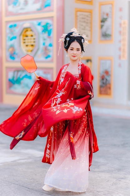 Vrouw jurk China Nieuwjaars portret van een vrouw persoon in traditionele kostuum vrouw in traditionele kostum Mooie jonge vrouw in een felrode jurk en een kroon van de Chinese koningin poseren