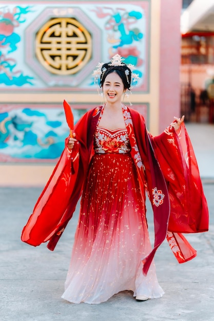 Vrouw jurk China Nieuwjaars portret van een vrouw persoon in traditionele kostuum vrouw in traditionele kostum Mooie jonge vrouw in een felrode jurk en een kroon van de Chinese koningin poseren