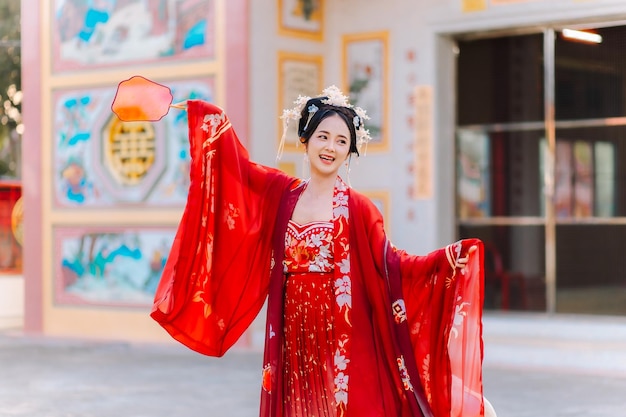 Vrouw jurk China Nieuwjaars portret van een vrouw persoon in traditionele kostuum vrouw in traditionele kostum Mooie jonge vrouw in een felrode jurk en een kroon van de Chinese koningin poseren