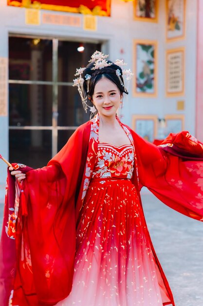 Vrouw jurk China Nieuwjaars portret van een vrouw persoon in traditionele kostuum vrouw in traditionele kostum Mooie jonge vrouw in een felrode jurk en een kroon van de Chinese koningin poseren