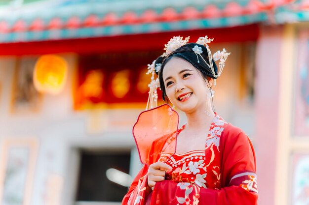 Vrouw jurk China Nieuwjaars portret van een vrouw persoon in traditionele kostuum vrouw in traditionele kostum Mooie jonge vrouw in een felrode jurk en een kroon van de Chinese koningin poseren