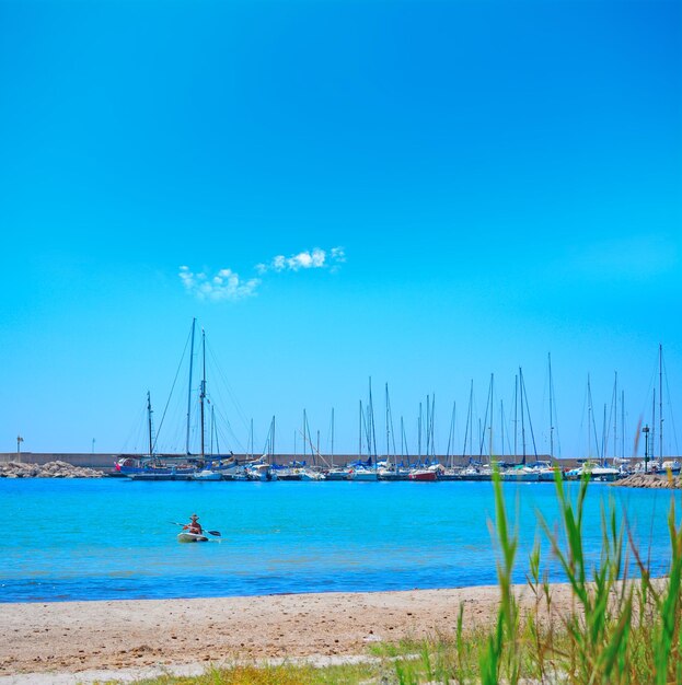 Vrouw kajakken in de kust van Alghero, Italië