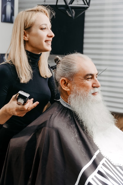 Vrouw kapper haar knippen tot een oude bebaarde man