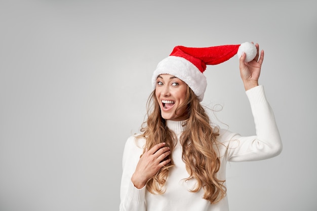 Vrouw kerst kerstmuts trui witte studio achtergrond