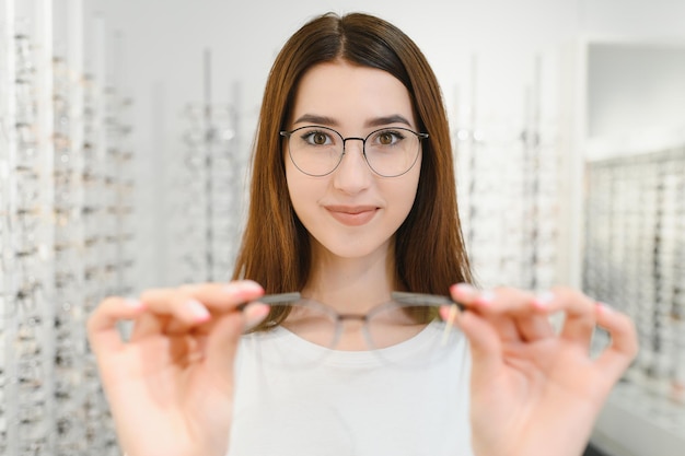 Vrouw kiest een bril in de winkel