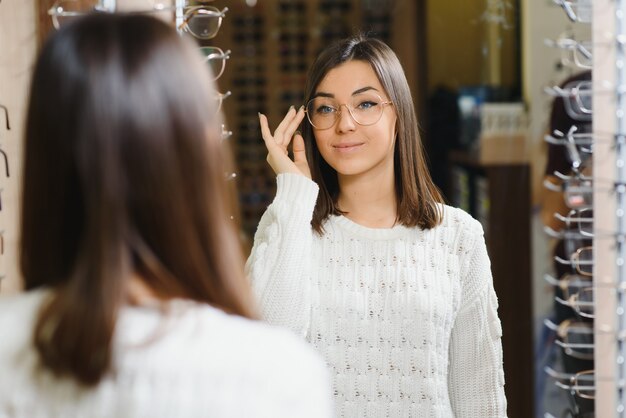 Vrouw kiest een bril in de winkel.