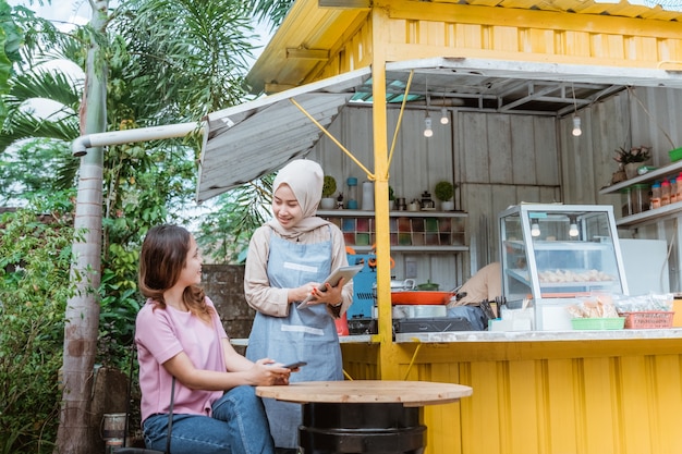 Vrouw kiest eten een menu dat een verkoper meebrengt