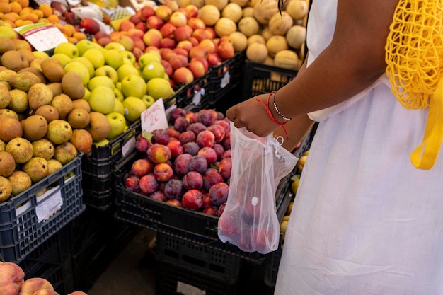Vrouw kiest groenten en fruit op boerenmarkt