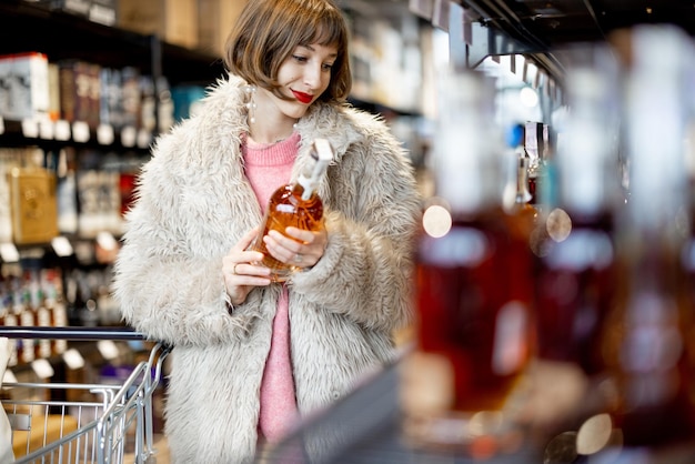 Vrouw kiest sterke alcohol in supermarkt