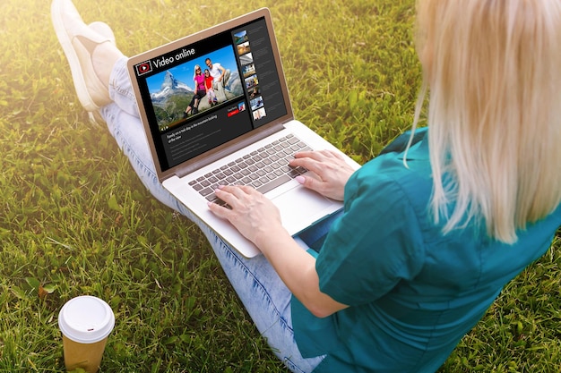 Vrouw kijken naar video's online op laptop.