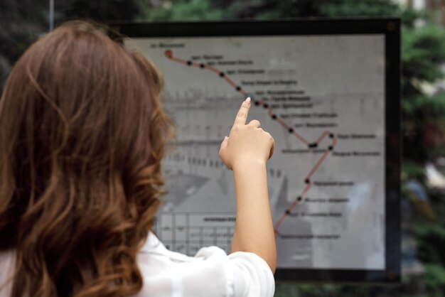 Vrouw kijkt naar de kaart van de route van het openbaar vervoer